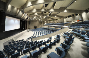 AUDITORIUM PAINTING - Auditorium painting involves the painting of auditoriums, theaters, and performance spaces to create an atmosphere that enhances the audience's experience. The process begins with surface preparation, including cleaning, repairing, and priming surfaces to ensure a smooth and durable finish. Special attention is given to acoustical panels, stage areas, and seating to maintain their functionality and appearance. Commercialpainting.com uses high-quality paints and finishes that are designed for use in auditoriums, ensuring long-lasting and vibrant colors. Auditorium painting requires careful planning, coordination with event schedules, and attention to detail to create a visually stunning and welcoming space for performances and events.